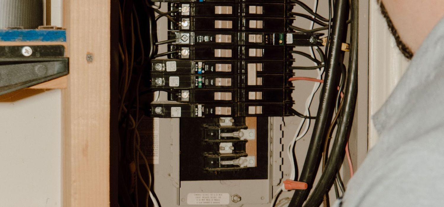 Electrical panel with multiple circuit breakers and visible wiring inside a residential service box.
